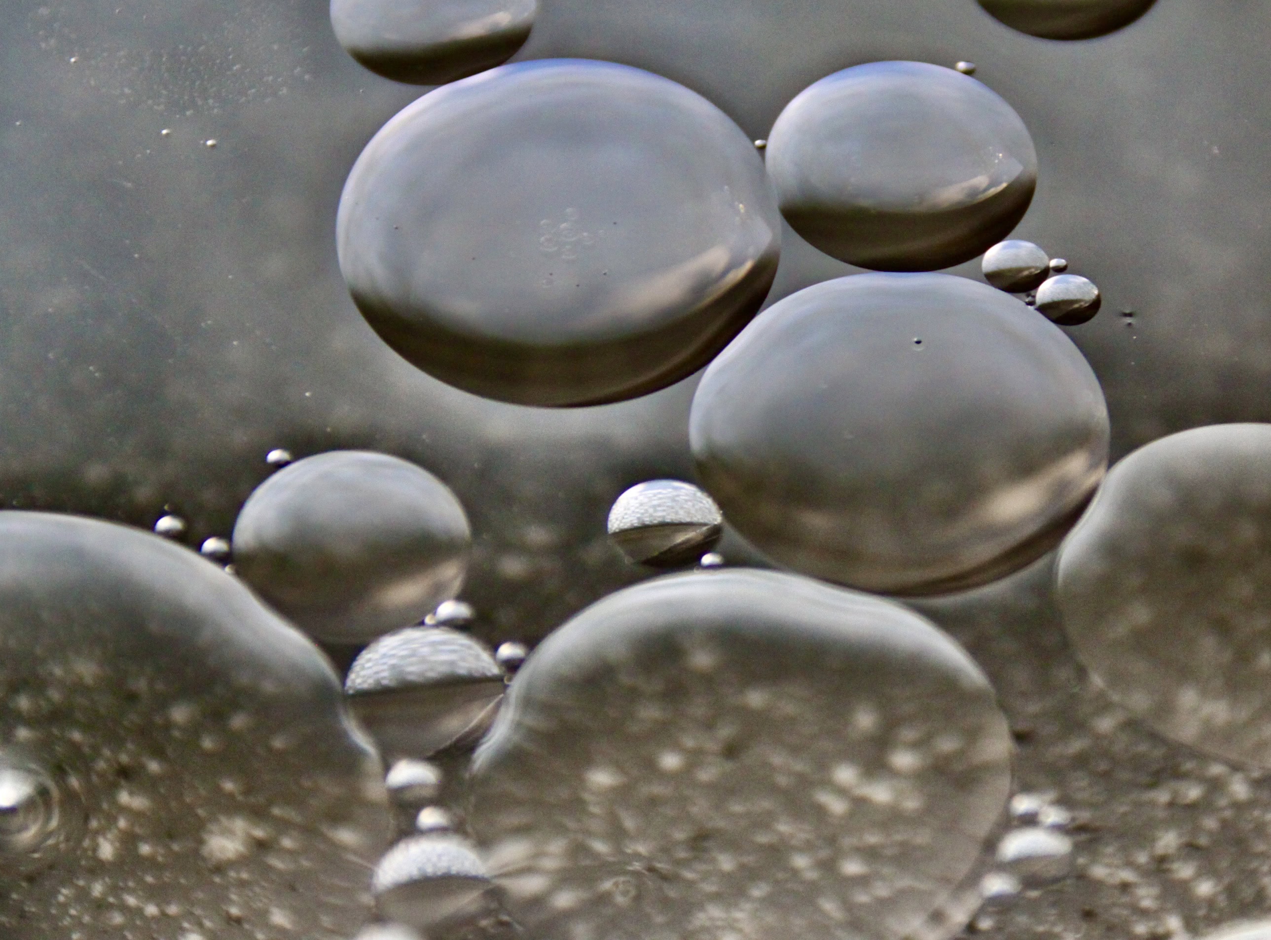 Oil floating on water by Jez Braithwaite