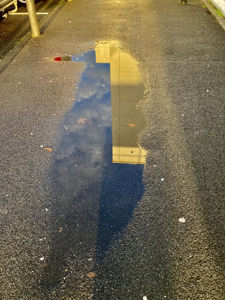 Building reflected in a puddle